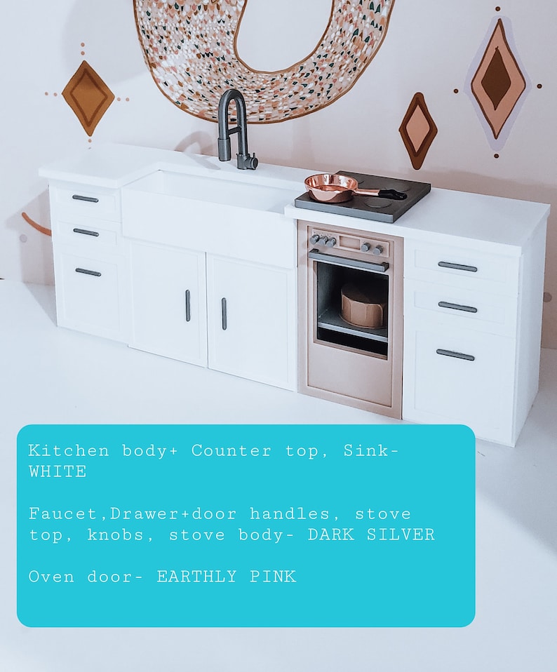 May include: A miniature white kitchen playset with a sink, stove, and oven. The countertop, sink, and kitchen body are white. The stove top, knobs, and body are dark silver. The oven door is a light pink colour. The text on the image reads: "Kitchen body+ Counter top, Sink- WHITE Faucet, Drawer+door handles, stove top, knobs, stove body- DARK SILVER Oven door- EARTHLY PINK"