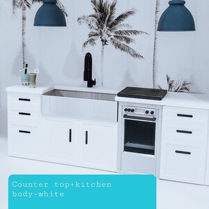 May include: A white kitchen cabinet with a farmhouse sink, black tap, and a stainless steel oven. The countertop is white and the cabinet doors have black handles. The backsplash features a tropical palm tree wallpaper.