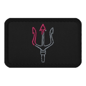 Może przedstawiać: Czarna prostokątna naszywka z motywem trójzębu. Trójząb jest wyszyty szarą i różową nicią. Naszywka ma czarną obwódkę i jest przeznaczona do odzieży lub akcesoriów.