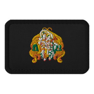 May include: A black embroidered patch with a gold and green design of a person sitting on a throne. The person is wearing a white robe and a crown.