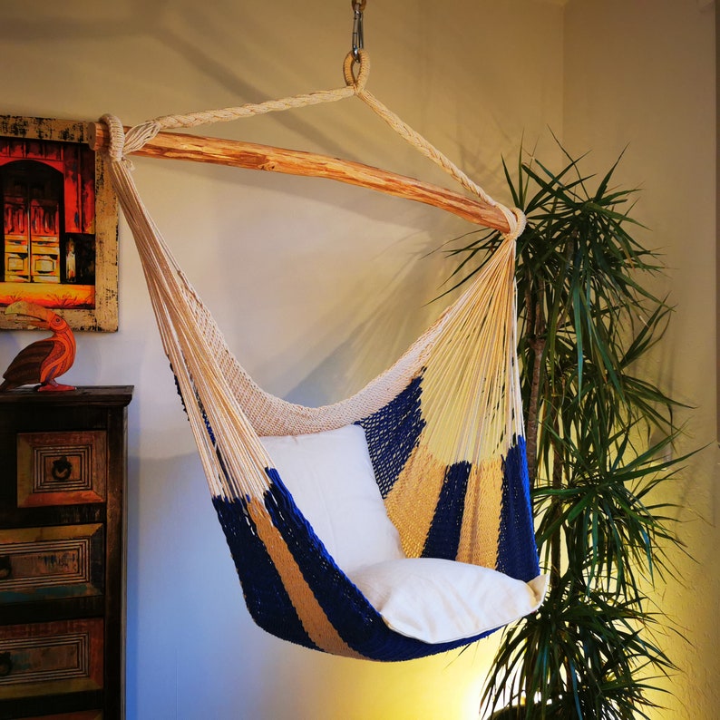May include: A white and blue hammock with a wooden frame. The hammock is hanging from the ceiling and is made of a woven material. The hammock is a popular choice for relaxing and enjoying the outdoors.