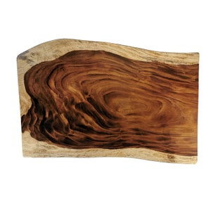 Op de afbeelding: Een grote, natuurlijke houten plaat met een levende rand. Het hout heeft een rijke bruine kleur met donkerbruine nerfpatronen. De plaat is glad en gepolijst.