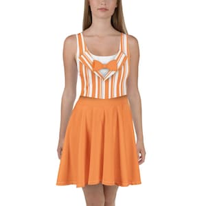 May include: A sleeveless dress featuring a white and orange striped top with a bow tie design and a solid orange skirt. The dress has a fitted bodice and a flared skirt, creating a playful and stylish look. The overall design is reminiscent of a vintage aesthetic.