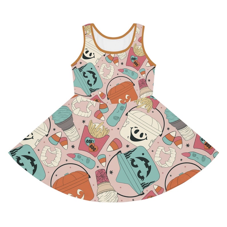 May include: A sleeveless skater dress with a light pink background and a repeating pattern of Halloween-themed illustrations. The pattern includes jack-o'-lanterns, ice cream cones, candy corn, and mummy buckets. The dress has a brown trim.