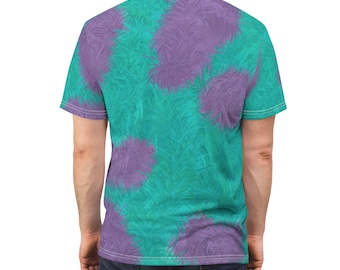 Puede incluir: Una camiseta de color turquesa y morado con efecto tie-dye y textura peluda. La camiseta tiene cuello redondo y mangas cortas.