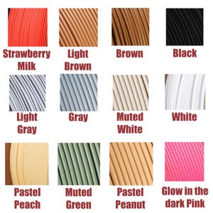 May include: A color palette featuring samples of 3D printing filament in various colors. Colors include Strawberry Milk, Light Brown, Brown, Black, Light Gray, Gray, Muted White, White, Pastel Peach, Muted Green, Pastel Peanut, and Glow in the dark Pink.