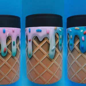 May include: Three insulated beverage holders with an ice cream cone design. Each holder features a waffle cone pattern, topped with dripping ice cream in pink, white, and blue, and colorful sprinkles. The holders have a black top.