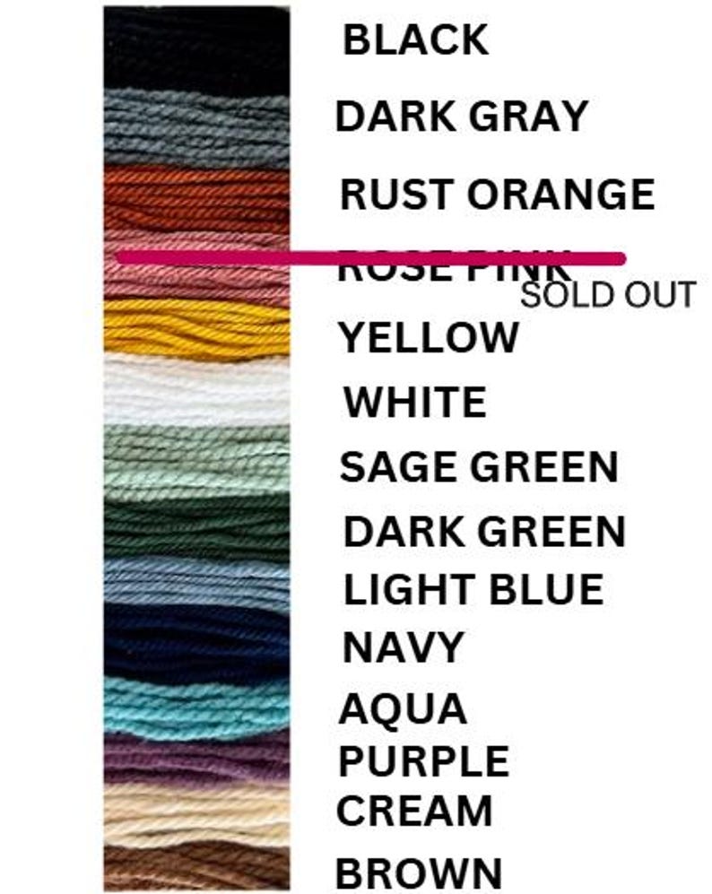May include: A color chart featuring a vertical arrangement of yarn samples in various hues. The colors include black, dark gray, rust orange, yellow, white, sage green, dark green, light blue, navy, aqua, purple, cream, and brown. The text "ROSE PINK SOLD OUT" is also present.