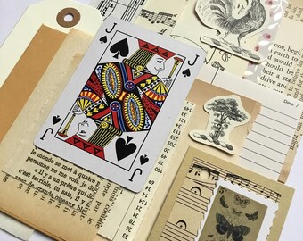May include: A collage of vintage paper scraps, including a playing card, sheet music, a rooster illustration, and a handwritten note. The playing card is the Jack of Spades, and the note includes the text "one, begin 1 earth to d would should be heir a sta drive and".