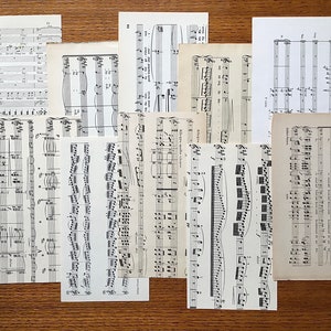 May include: A collection of vintage sheet music pages with musical notes and staff lines. The pages are in black and white and have a worn, aged look.