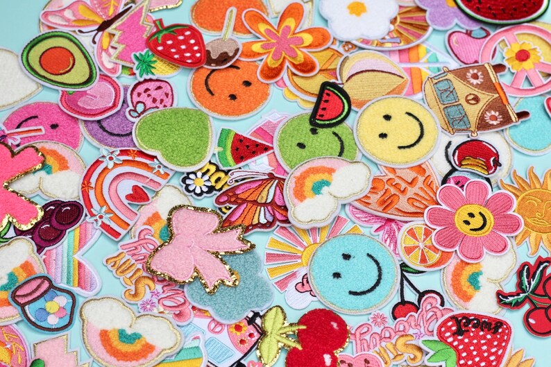 以下が含まれることがあります： 虹、スマイリーフェイス、チェリー、蝶、VWバスなど、さまざまなデザインが施されたカラフルなアイロン接着パッチのコレクション。パッチは、衣類、バッグ、その他のアクセサリーに個性的なタッチを加えるのに最適です。