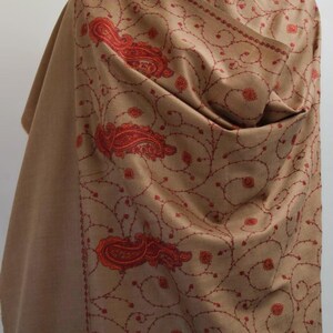 May include: A brown shawl with intricate red embroidery of paisley patterns and floral designs.