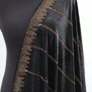 May include: Black velvet shawl with a diagonal pattern of gold and silver rhinestones.