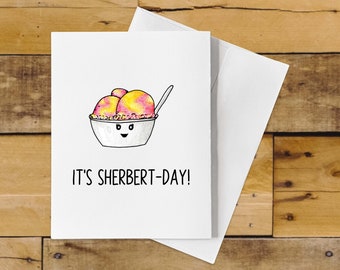 Puede incluir: Una tarjeta blanca con una ilustración dibujada a mano de un tazón de sorbet con una cuchara. El tazón tiene una cara sonriente. El texto en la tarjeta dice "¡Es el día del sorbet!"