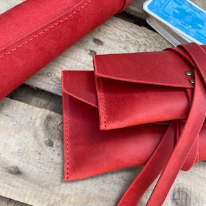 May include: Red leather card carrying case with a strap and a separate roll-up case for cards.