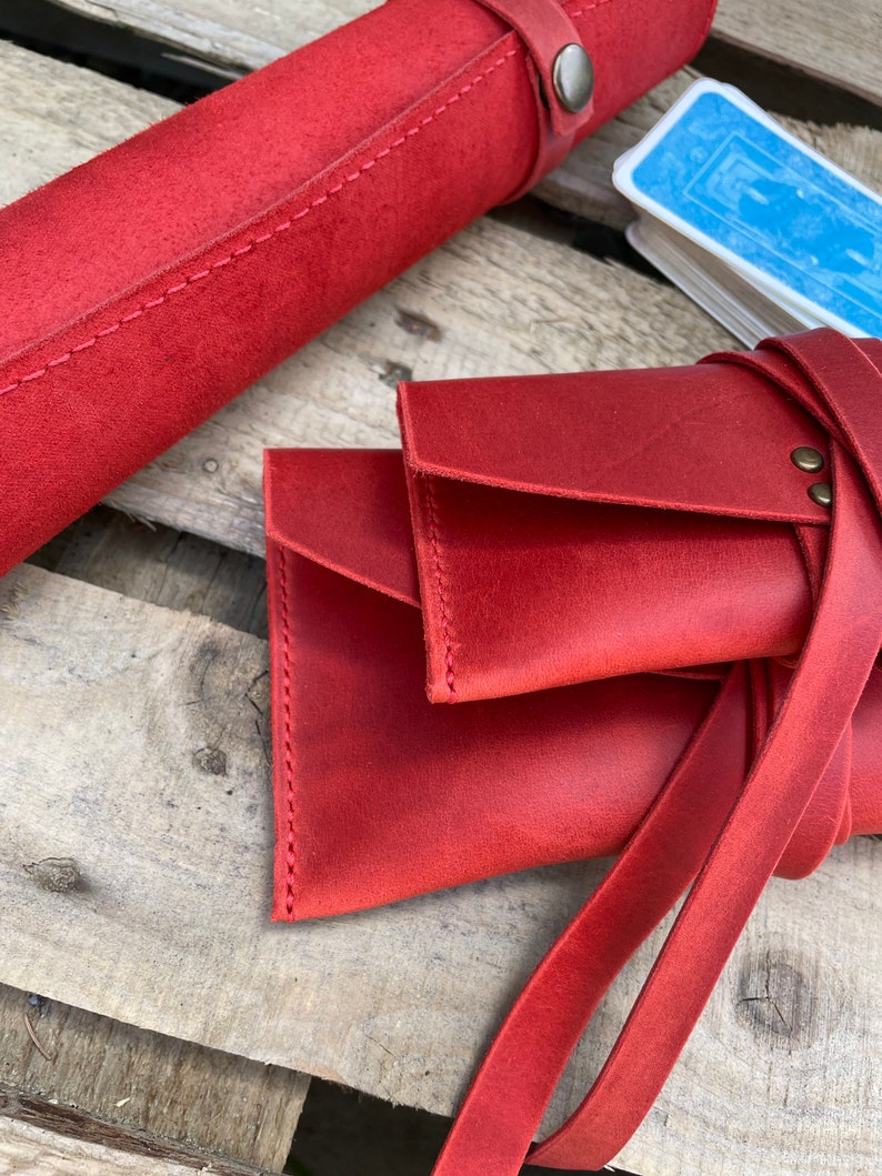 May include: Red leather card carrying case with a strap and a separate roll-up case for cards.