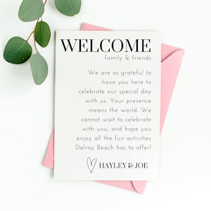 May include: A white card with black text that reads "WELCOME family & friends" and "We are so grateful to have you here to celebrate our special day with us. Your presence means the world. We cannot wait to celebrate with you, and hope you enjoy all the fun activities Delray Beach has to offer!" followed by a heart symbol and "HAYLEY & JOE".