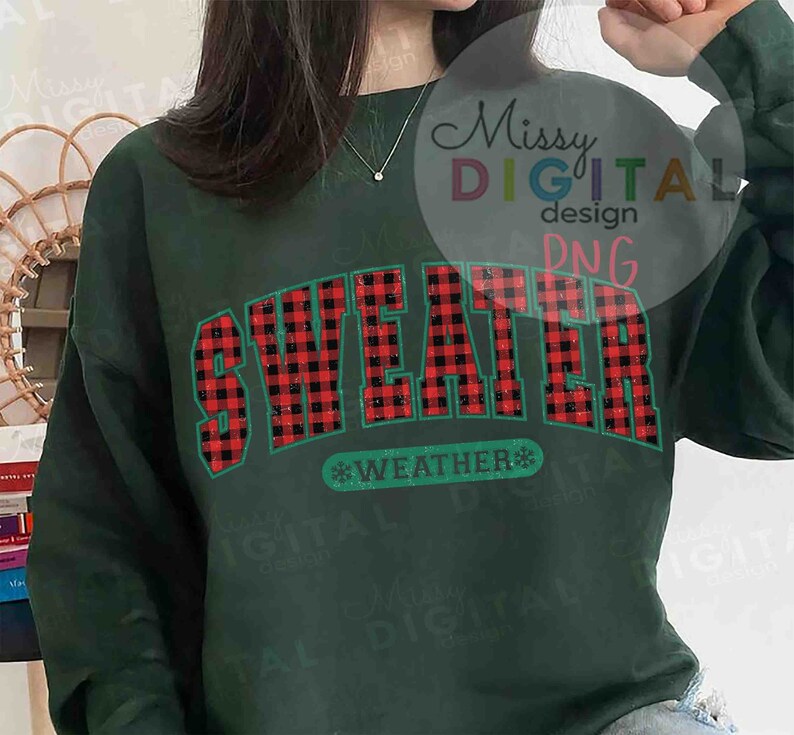 Puede incluir: Sudadera verde oscuro con la frase "SWEATER WEATHER" en un dise&ntilde;o de cuadros rojos y negros. El texto est&aacute; delineado en color turquesa, con un copo de nieve. Prenda de vestir casual y de temporada.