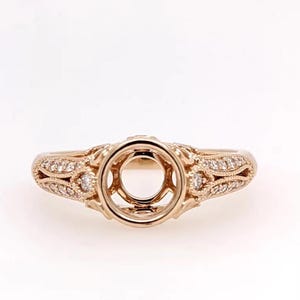 May include: A rose gold engagement ring setting with a round centre stone setting and a delicate diamond band.