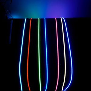 May include: A collection of glowing, flexible LED light strips in various colors, including blue, red, green, and pink, against a black background. The lights are suspended from above, creating a vibrant and colorful display.