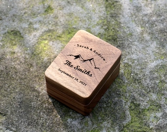 Könnte beinhalten: Eine Holzkiste für Ringe mit einem eingravierten Bergmotiv und dem Text "Sarah & Andrew - The Smiths - September 18, 2021".