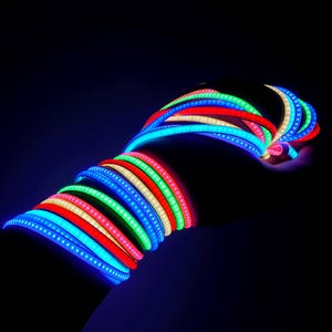 May include: A collection of flexible LED light strips in various colors, including red, green, blue, and white. The strips are arranged in a spiral pattern, creating a vibrant and colorful display. The image is set against a dark background.