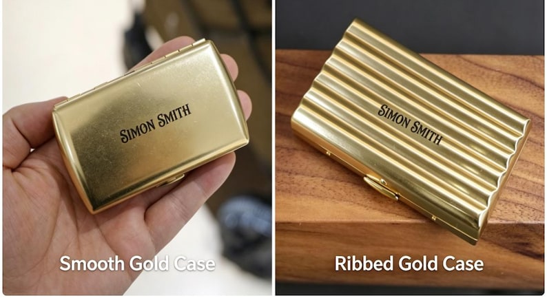 May include: Gold-colored business card case with the name "SIMON SMITH" printed in black. The case is rectangular and has a smooth surface. The image also shows a ribbed gold case with the same name.