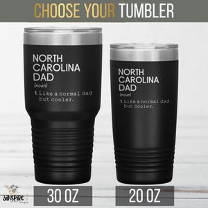 May include: Two black insulated tumblers with silver rims. The tumblers have the text "NORTH CAROLINA DAD" and the phrase "Like a normal dad but cooler." One is 30 oz, the other is 20 oz. The top banner reads "CHOOSE YOUR TUMBLER."