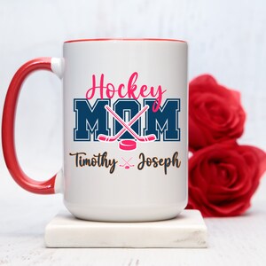 a red and white coffee mug with hockey mom on it