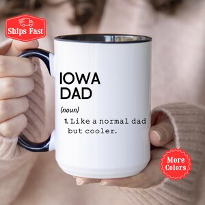 May include: White ceramic mug with a black interior and handle. The mug features the text "IOWA DAD" in bold black letters, with the definition: "Like a normal dad but cooler."
