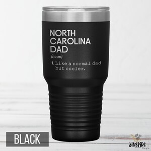May include: A black insulated tumbler with a silver lid. The tumbler features the text "NORTH CAROLINA DAD (noun) 1. Like a normal dad but cooler." The word "BLACK" is printed at the bottom.