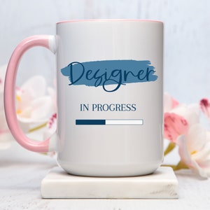 a white and pink coffee mug sitting on top of a table