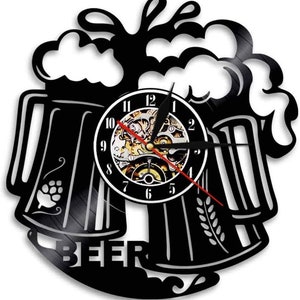 Può includere: Orologio da parete nero a tema birra. L'orologio presenta due boccali di birra con schiuma, un quadrante con ingranaggi visibili e la scritta "BEER" in basso. Le lancette sono nere e rosse.