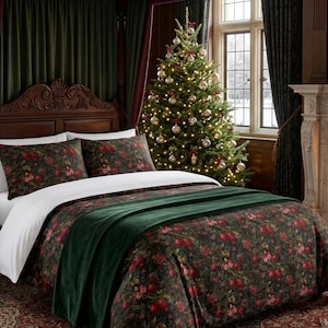 Peut inclure: Une parure de lit composée d'une housse de couette et de deux taies d'oreiller vert foncé avec un imprimé botanique de grenades rouges et de fleurs. Un jeté de lit en velours vert foncé uni est posé au pied du lit.