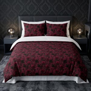 Pu&ograve; includere: Un set di biancheria da letto composto da un copripiumino e due federe con un motivo floreale rosso scuro e nero. Il copripiumino presenta un lato inferiore bianco tinta unita e bordi bianchi, in contrasto con la stampa di rose bordeaux.