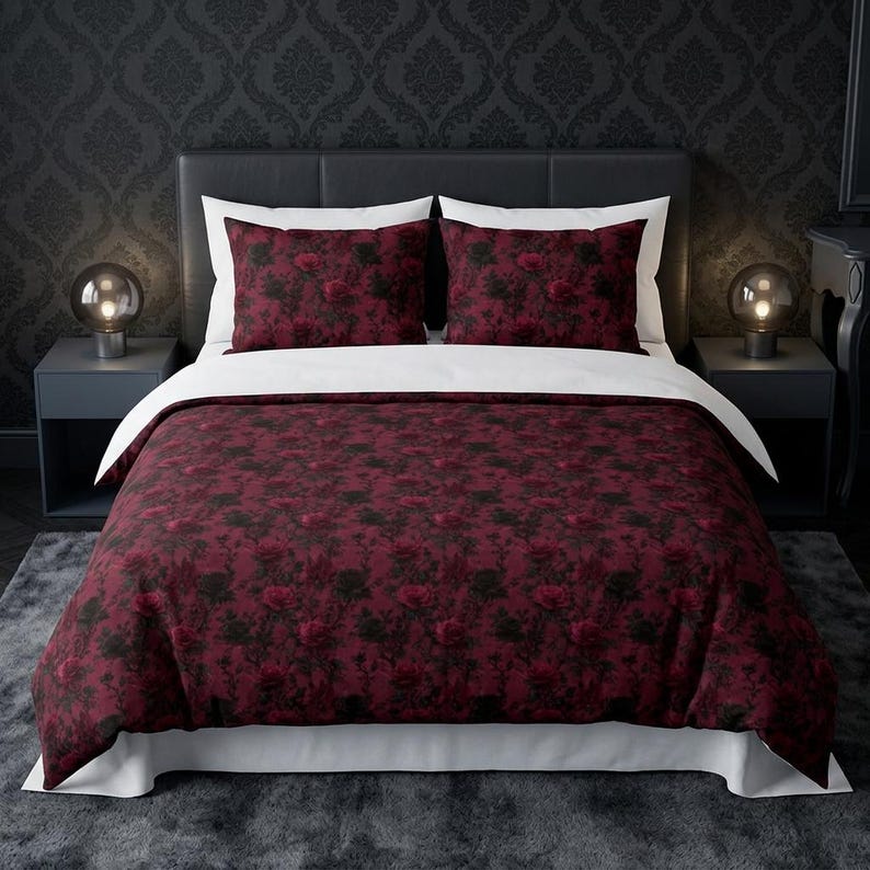 Pu&ograve; includere: Un set di biancheria da letto composto da un copripiumino e due federe con un motivo floreale rosso scuro e nero. Il copripiumino presenta un lato inferiore bianco tinta unita e bordi bianchi, in contrasto con la stampa di rose bordeaux.
