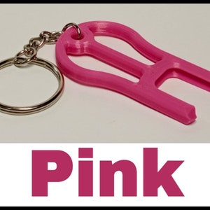 May include: A pink plastic keychain tool with a key ring. The tool has a unique shape and is designed to help open things.