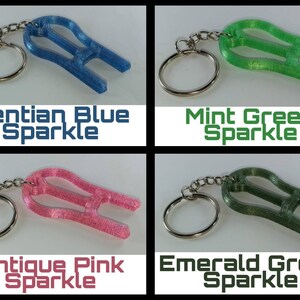 May include: Four keychains with different colored sparkly finishes: Gentian Blue Sparkle, Mint Green Sparkle, Antique Pink Sparkle, and Emerald Green Sparkle.