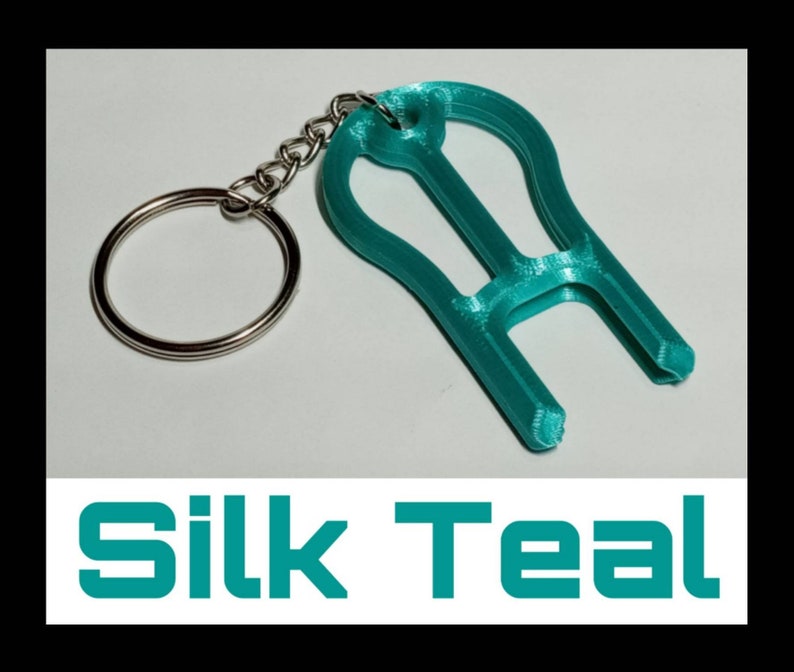 May include: Teal blue 3D printed keychain with a key ring. The keychain is shaped like a light bulb with a small loop at the top.
