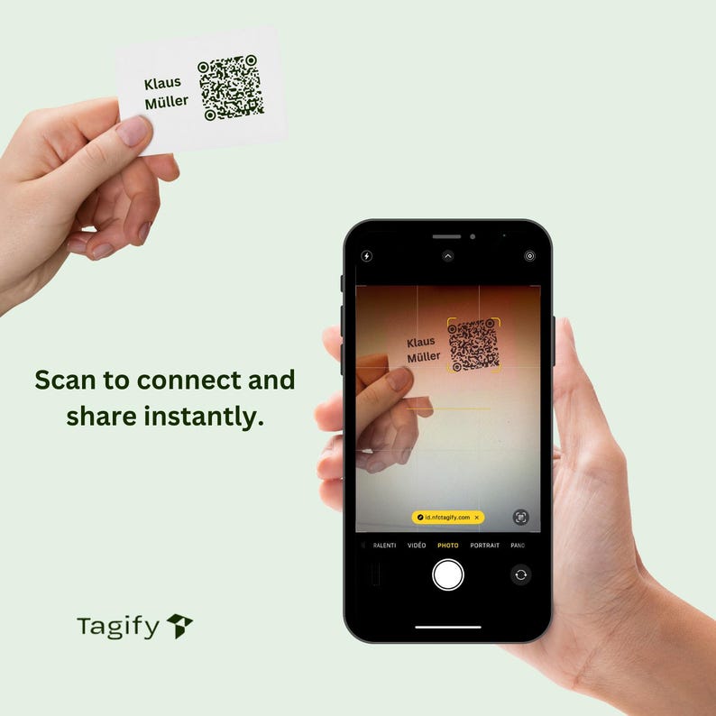 May include: A smartphone displaying a QR code on the screen. The QR code is being scanned by a hand holding a business card with the text "Klaus M&uuml;ller" and a QR code. The text "Scan to connect and share instantly." is displayed below the image. The text "Tagify" is displayed at the bottom of the image.