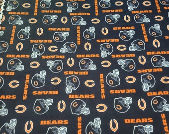 May include: Black fabric with a repeating pattern of orange and white Chicago Bears logos. The logos include the team name "BEARS" and a football helmet.