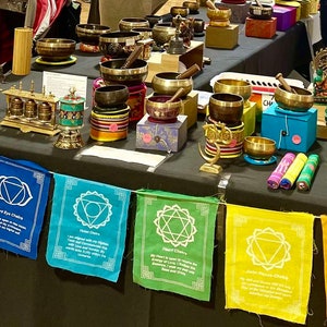 以下が含まれることがあります： さまざまなシンギングボウル、チャクラのシンボルが付いた装飾フラッグ、その他のスピリチュアルアイテムの展示。ボウルは真鍮と青銅製で、フラッグはさまざまな色です。その他のアイテムには、像やお香が含まれます。