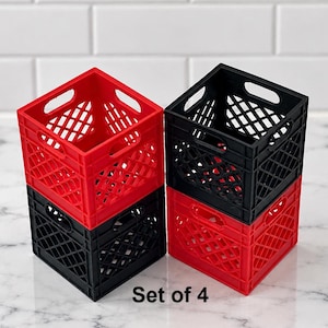 May include: A set of four square plastic storage crates featuring a diamond-shaped lattice pattern and integrated handles. Two crates are red and two are black, stacked in two columns of two. The text Set of 4 is printed in black.