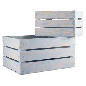 May include: Two light blue wooden crates with a rustic finish. The larger crate has three horizontal slats and the smaller crate has two horizontal slats.