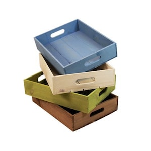 May include: Four wooden trays stacked on top of each other, in blue, natural, green, and brown. Each tray has a rectangular shape with a handle cut out on each side. The trays are empty and appear unused.