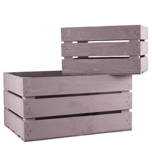 May include: Two wooden crates, one stacked on top of the other. The crates are a light gray color and have a rustic look. The larger crate has three horizontal slats, while the smaller crate has two.
