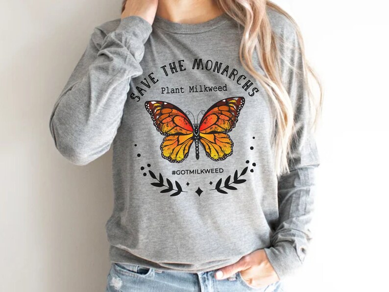 K&ouml;nnte beinhalten: Graues Langarmshirt mit einem Motiv eines Monarchfalters und dem Text "Save the Monarchs Plant Milkweed #GotMilkweed".