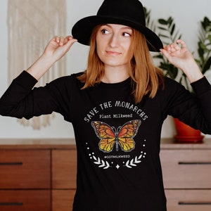 K&ouml;nnte beinhalten: Schwarzes Langarmshirt mit einem Motiv eines Monarchfalters und dem Text "Save the Monarchs Plant Milkweed #gotmilkweed".