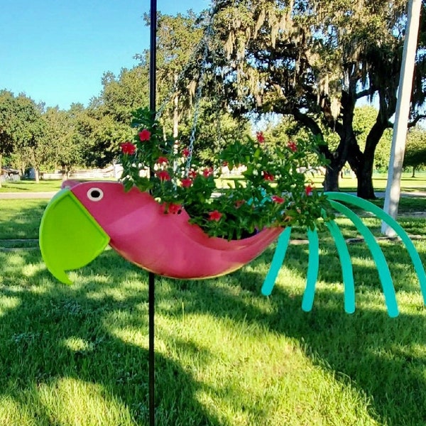 Lily. Un beau perroquet au corps rose avec un bec vert et des plumes de queue bleu sarcelle. Une sensation tropicale de Key West qui apporte beaucoup de sourires.