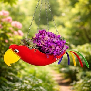 May include: A red parrot-shaped hanging planter filled with purple flowers and greenery. The planter has a yellow beak, a red eye, and colorful tail feathers. It hangs from a silver chain against a blurred green background.
